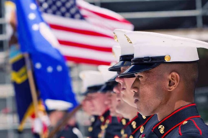 shutterstock_355868381.jpg U.S. Marines in uniform standing in formation with flags in the background