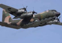 Military C-130 Hercules aircraft flying against a blue sky