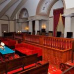 Interior of a historic courtroom featuring wooden furniture and elegant decor