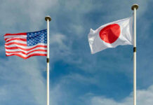 Japan’s Stunning Pledge Sparks Beijing Fury USA and Japan flags flying on flagpoles.