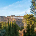 Electrocution Horror Shakes Hollywood — Oh NO! Hollywood sign on hill surrounded by trees and buildings.
