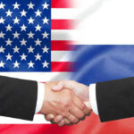 Trump’s Secret Deal With Russia — Ukraine NOTIFIED Hands shaking in front of USA and Russia flags.