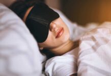 Sleep Crisis? – State-by-State Breakdown A woman wearing a sleep mask, resting in bed