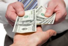 Walmart Under Pressure — Cashless Society REJECTED Two hands exchanging cash bills in a business context