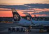 Aircraft tails with a sunset backdrop at an airport