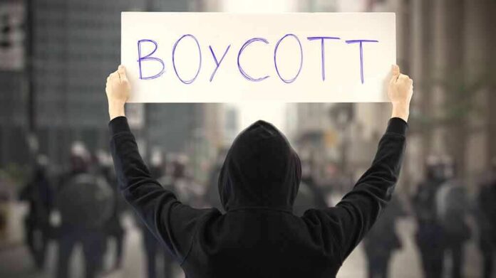 Person holding a sign that says BOYCOTT during a protest