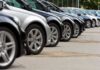 A row of parked black and silver cars in a dealership