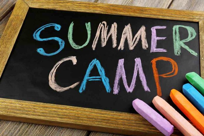 shutterstock_228380488.jpg Chalkboard with colorful writing that says Summer Camp and several pieces of chalk