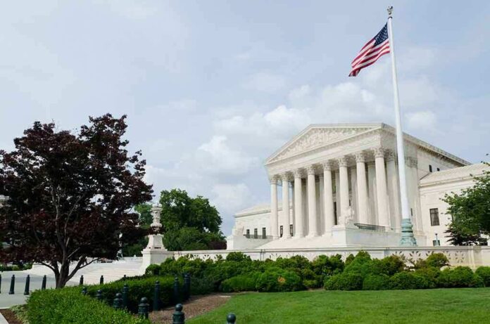 shutterstock_78346810.jpg The U.S. Supreme Court building with an American flag and landscaped grounds