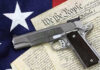 Gun on U.S. Constitution and flag.