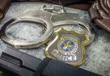 Sheriffs Handcuffed by Supreme Court Handcuffs, officer badge, and firearm on textured surface.