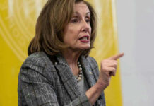 Pelosi SENDS TRUMP A Cryptic Warning Woman speaking and pointing, wearing a plaid jacket.