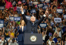 People on stage celebrating at a political rally.
