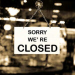 Closed sign hanging in a shop window.