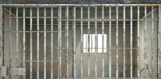 Empty rusty prison cell with a small window.