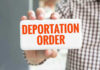 Harvard Professor’s Poor Judgment Sparks DEPORTATION Hand holding sign with Deportation Order text.
