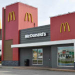 Massive McDonald’s COLLAPSE – Locations Shuttering Fast McDonalds restaurant exterior with logo and drive-thru sign.
