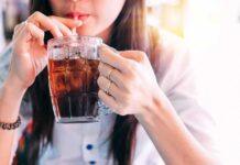 Corporate UPHEAVAL — PepsiCo Cuts Deep A woman sipping a cold beverage from a glass mug