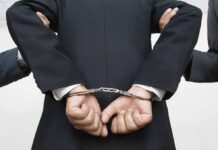 Mental Health CEO Arrested After MELTDOWN A person in a suit with hands cuffed behind their back