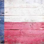 Abbott’s Shocking Move — UNPRECEDENTED Branding! Texas flag displayed on a wooden background