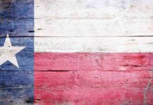 Abbott’s Shocking Move — UNPRECEDENTED Branding! Texas flag displayed on a wooden background