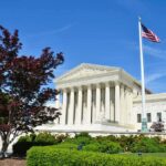 Supreme Court Faces Birthright Citizenship Showdown Supreme Court building with American flag and surrounding greenery