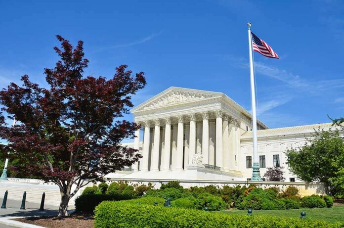 shutterstock_141389569.jpg Supreme Court building with American flag and surrounding greenery