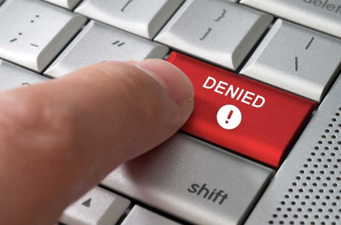shutterstock_145675649.jpg A finger pressing a red DENIED button on a computer keyboard
