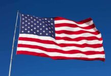 104-Year-Old Army Vet Delivers SHOCKING Arena Moment Waving American flag against a clear blue sky