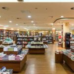 Interior view of a bookstore with shelves filled with books and wooden furniture