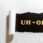 Torn paper revealing UH-OH text underneath.