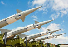 HYPERSONIC Threat Targets U.S. Allies Multiple missiles pointed upward on launchers against blue sky.