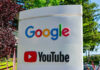 Google and YouTube sign with trees in background.