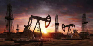 Oil rigs operating at sunset in a desert landscape.