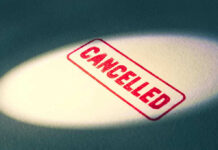 Red Cancelled stamp under a spotlight.