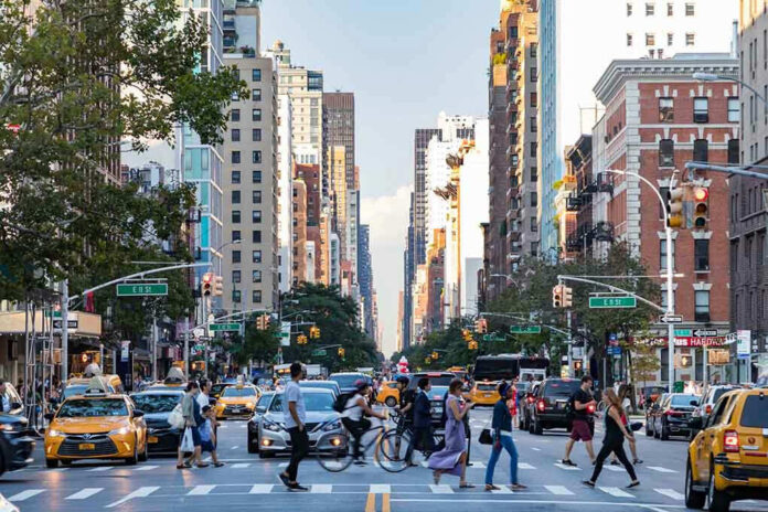 https://drive.google.com/drive/u/0/search?q=new%20york%20type:image Busy city street with pedestrians, cars, and tall buildings.