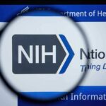 NIH logo viewed through a magnifying glass on a digital screen