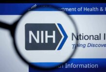 NIH logo viewed through a magnifying glass on a digital screen