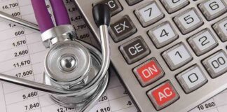 A stethoscope resting on a calculator and financial data sheets