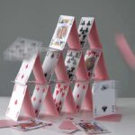 A house of cards collapsing with some cards in motion