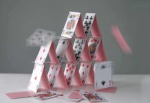 A house of cards collapsing with some cards in motion