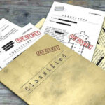 DOJ Epstein Dump—WHO’S The VILLIAN NOW? Classified documents with Top Secret stamps on wooden surface.