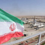 Iranian flag near an industrial gas refinery.