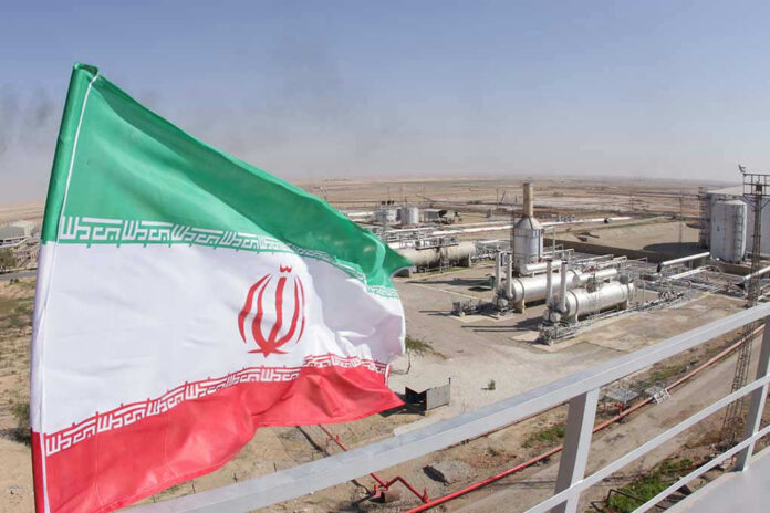 1227310843 Iranian flag near an industrial gas refinery.