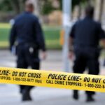 Navy Reservist FLEES to Hong Kong After Horrific Discovery Police officers walking past caution tape at a crime scene