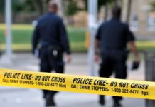 Navy Reservist FLEES to Hong Kong After Horrific Discovery Police officers walking past caution tape at a crime scene