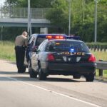 Police officer conducting a traffic stop on a highway