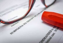 Close-up of a subpoena document with reading glasses and a highlighter