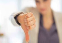 Businesswoman showing a thumbs down gesture in an office setting