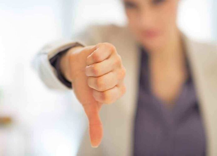 Businesswoman showing a thumbs down gesture in an office setting